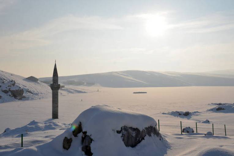 Minarja që ngrihet mbi liqenin e mbuluar nga akulli