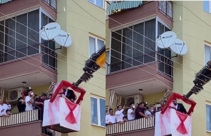 Dhëndri merr nusen nga ballkoni me vinç (Video)