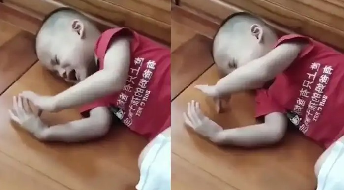 Fëmija qan në gjumë dhe lëviz me dorë ekranin e padukshëm