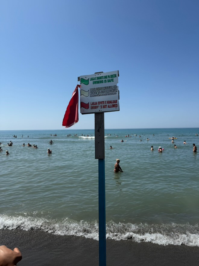 Në breg janë vendosur flamuj të kuq, por deti është plot me njerëz, cili është qëllimi?