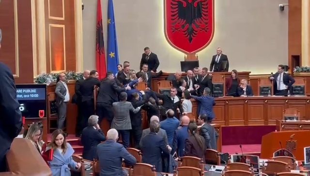 Klevis Balliu tenton të hipë mbi tavolinë, por bie sipër Albana Vokshit