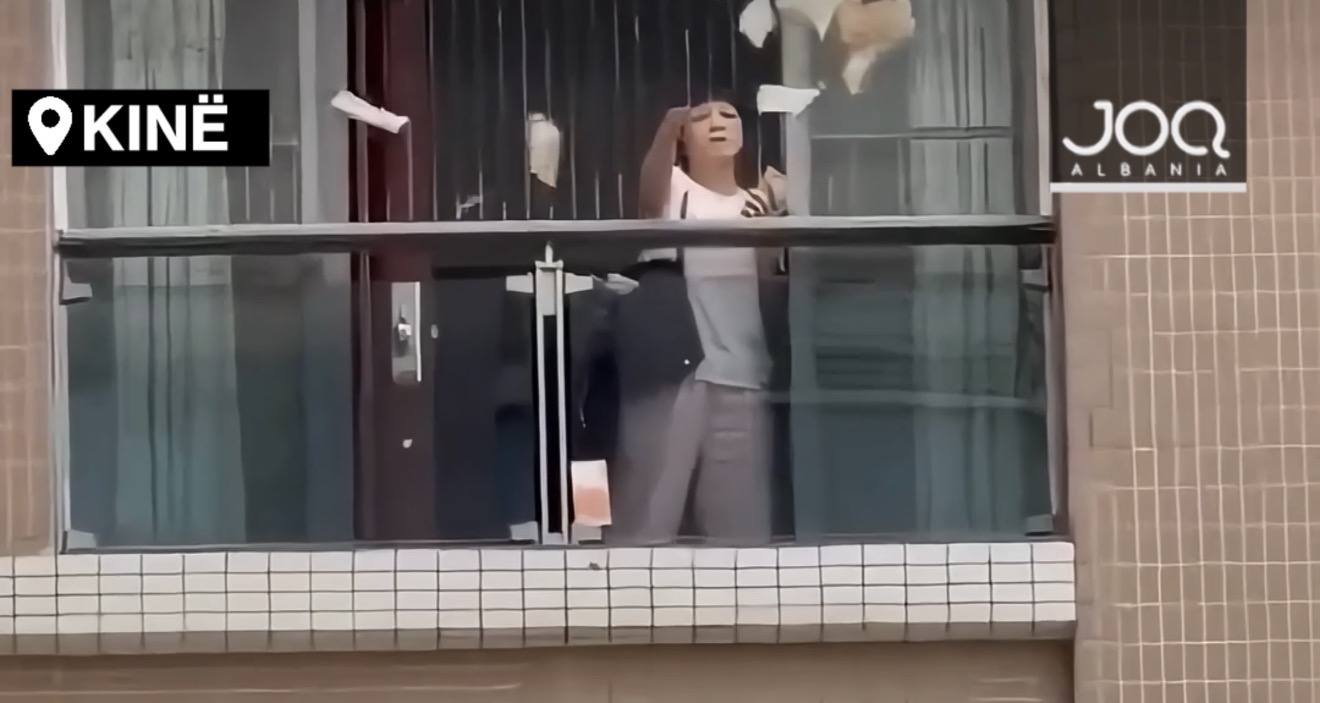 Pas sherrit me burrin gruaja ia fal paratë kalimtarëve nga ballkoni