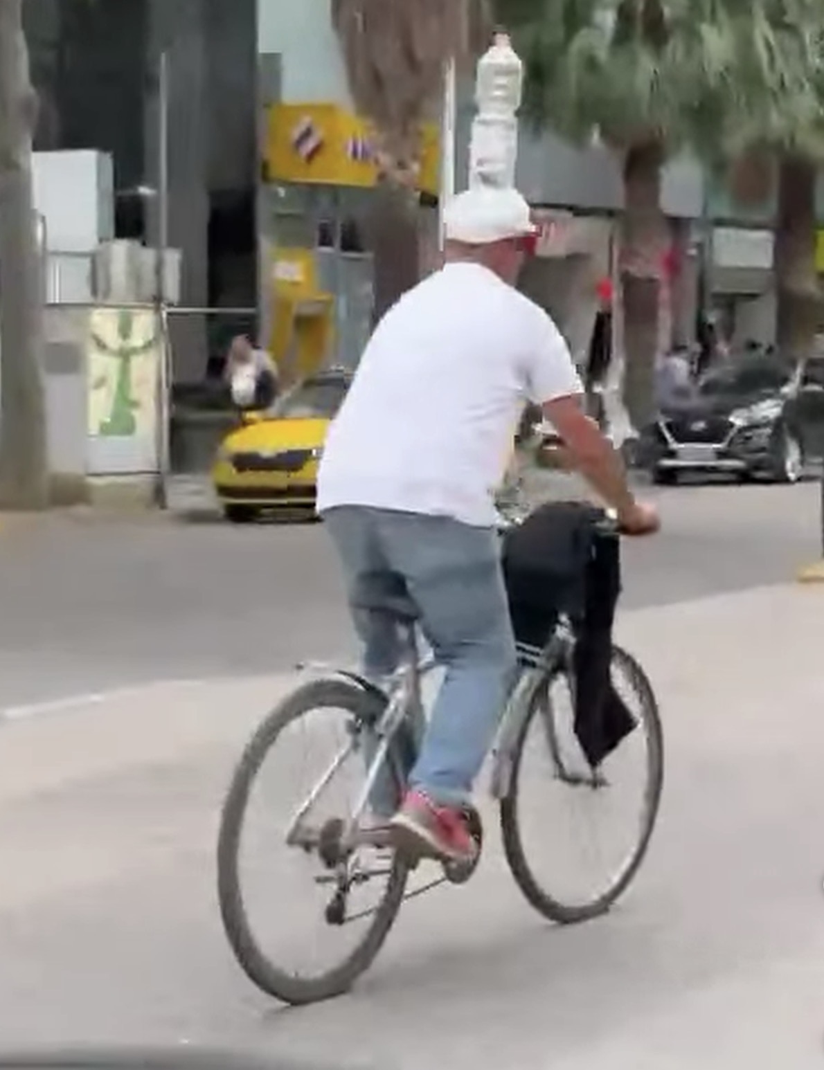 Qytetari sfidon vapën! Balancon shishen mbi kokë teksa ecën me biçikletë