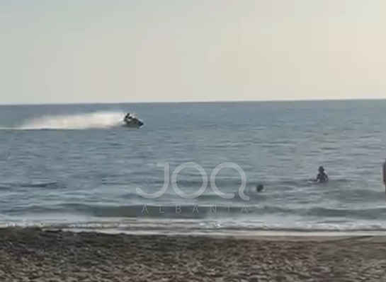 Jetski kalon pranë pushuesve në plazhin e Spillesë