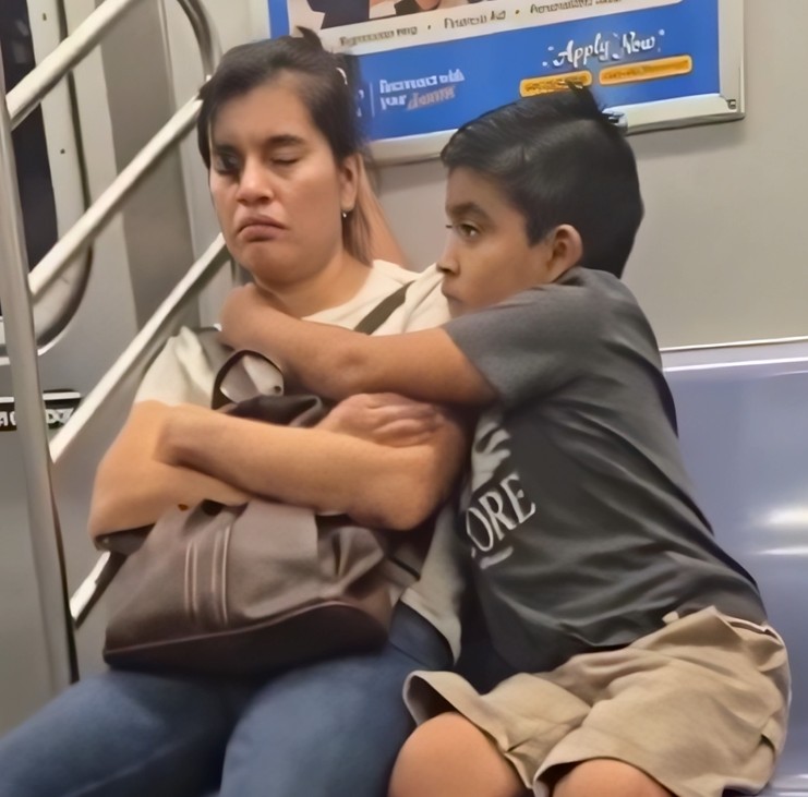 Nëna e lodhur po dremiste në metro, djali e mbron të mos përplasë kokën