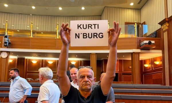 Mërgimtari proteston në Kuvend me pankartën “Kurti n’burg”, një tjetër ia heq nga duart