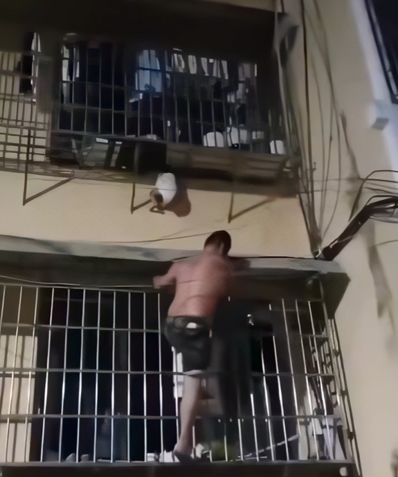 Burri ngjitet nga kangjellat dhe shpëton foshnjën që varej nga kati i dytë