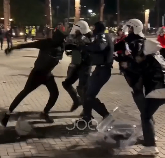 I riu përleshet me disa efektivë  vajza i del në mbrojtje  por policët e rrëzojnë dhe e godasin në tokë